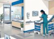 A gloved healthcare cleaner disinfecting an examination room surface.