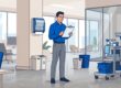 A facilities manager checks a clipboard in a clean, organized office.